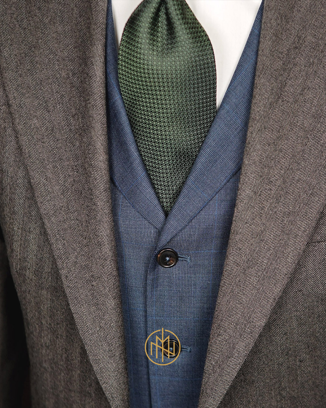 Detale kroju kamizelki na miarę z klapami szalowymi i błękitną kratą