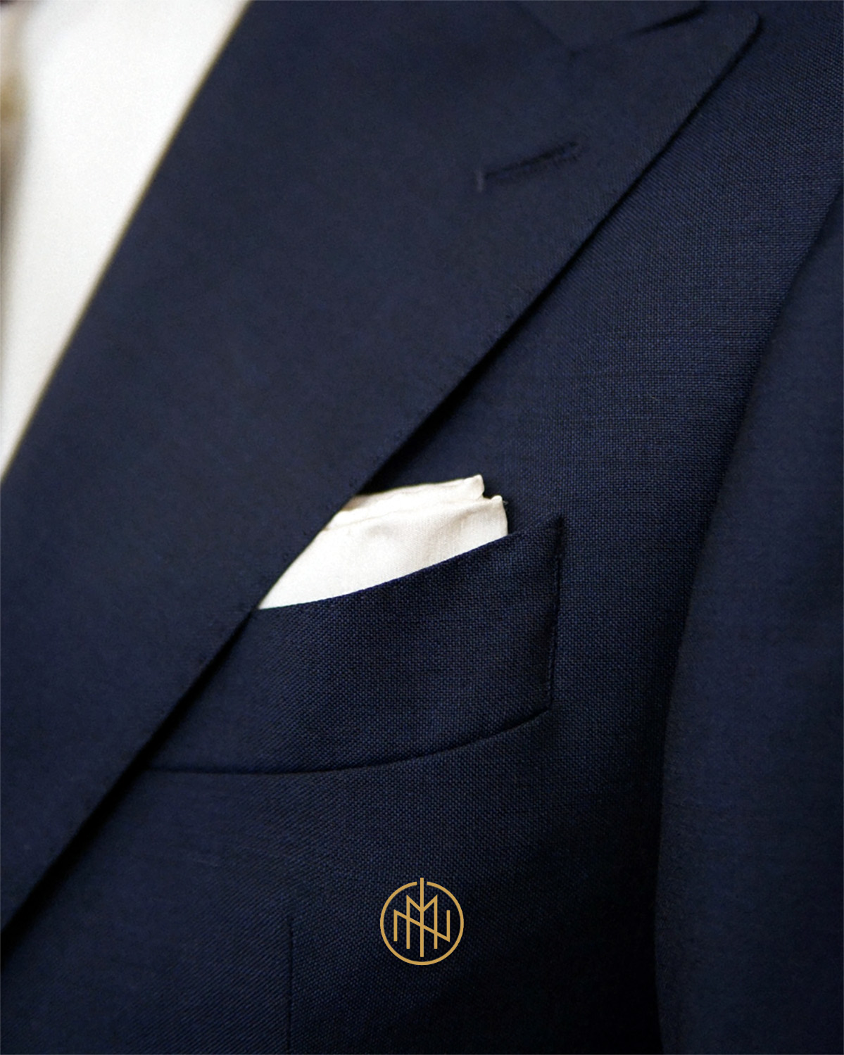 Szeroka ostra klapa marynarki, ręcznie szyta butonierka milanese, granatowy garnitur na miarę Poznań, luksusowa tkanina Alfred Brown.